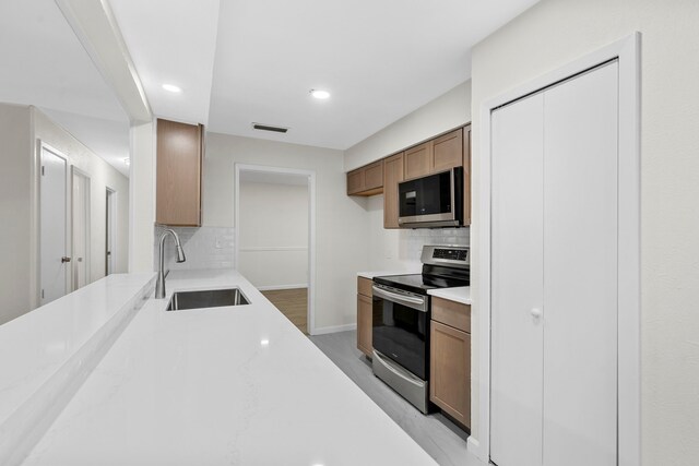 1828 Tracey Cir, Irving, TX 75060 - kitchen with stainless steel appliances, tasteful backsplash, light countertops, recessed lighting, and brown cabinets