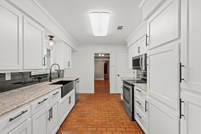 119 Locust Ct, Oak Leaf, TX 75154 - kitchen with appliances with stainless steel finishes, arched walkways, decorative backsplash, ornamental molding, and brick patterned flooring