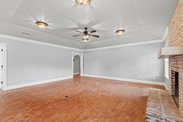 119 Locust Ct, Oak Leaf, TX 75154 - unfurnished living room featuring a brick fireplace, brick flooring, a ceiling fan, ornamental molding, and a tray ceiling