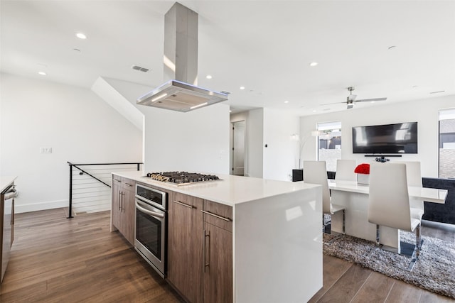 4726 Manett St Unit 101, Dallas, TX 75204 - kitchen featuring appliances with stainless steel finishes, island range hood, dark wood finished floors, open floor plan, and a large island