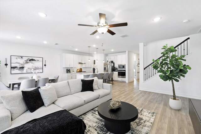 1213 Bonsmara Dr, Northlake, TX 76247 - living area featuring stairway, a ceiling fan, light wood finished floors, and recessed lighting