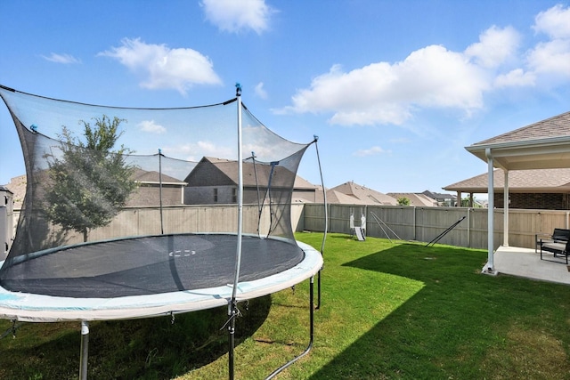1213 Bonsmara Dr, Northlake, TX 76247 - fenced backyard featuring a trampoline and a patio area