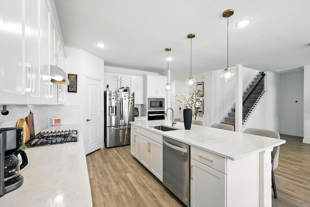 1213 Bonsmara Dr, Northlake, TX 76247 - kitchen featuring stainless steel appliances, white cabinets, a kitchen bar, light wood-style floors, and recessed lighting