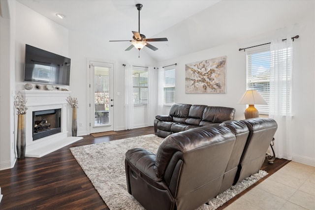 5704 Ridgeson Dr, Mckinney, TX 75071 - living room featuring ceiling fan, a fireplace with raised hearth, wood finished floors, and vaulted ceiling