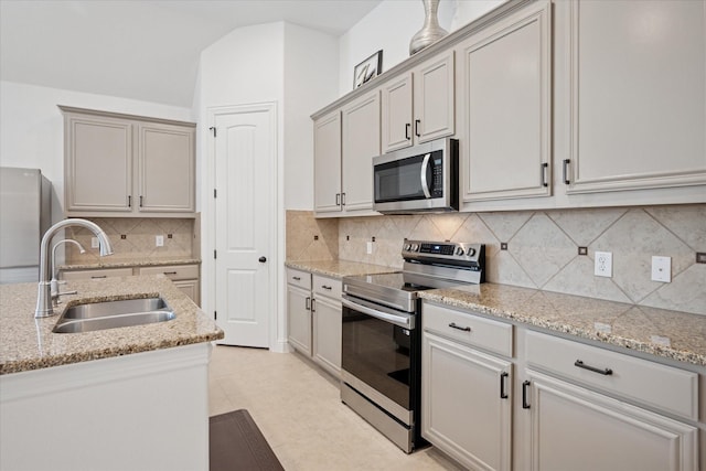 5704 Ridgeson Dr, Mckinney, TX 75071 - kitchen featuring stainless steel appliances, light stone countertops, decorative backsplash, light tile patterned flooring, and lofted ceiling