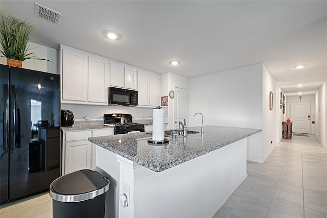 1773 Courage Crk, Crandall, TX 75114 - kitchen with black appliances, light tile patterned flooring, white cabinetry, light stone counters, and a kitchen island with sink