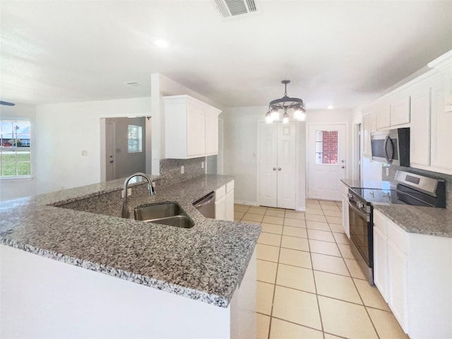 6231 Bridle Trl, Caddo Mills, TX 75135 - kitchen featuring stainless steel appliances, white cabinets, a peninsula, a chandelier, and light tile patterned floors