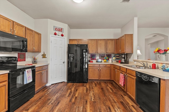 118 Independence Trl, Forney, TX 75126 - kitchen with black appliances, light countertops, arched walkways, dark wood-style flooring, and brown cabinetry