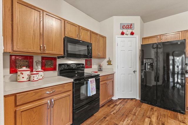 118 Independence Trl, Forney, TX 75126 - kitchen with black appliances, light countertops, light wood-type flooring, and brown cabinetry