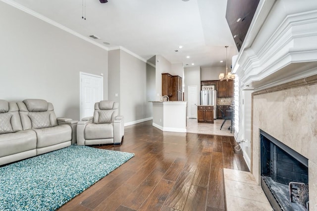 114 Stonecreek Dr, Irving, TX 75063 - living room featuring a tiled fireplace, wood finished floors, recessed lighting, crown molding, and a chandelier