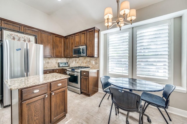 114 Stonecreek Dr, Irving, TX 75063 - kitchen featuring stainless steel appliances, a chandelier, decorative backsplash, light stone countertops, and hanging light fixtures