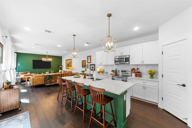 2340 Starks Ave, Dallas, TX 75215 - kitchen with appliances with stainless steel finishes, a chandelier, open floor plan, a breakfast bar, and backsplash
