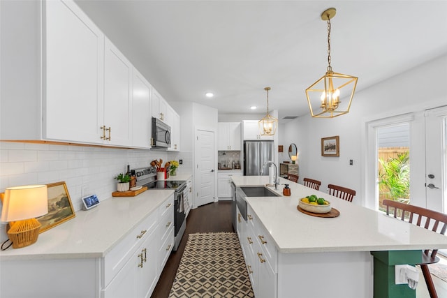 2340 Starks Ave, Dallas, TX 75215 - kitchen featuring appliances with stainless steel finishes, a chandelier, a center island with sink, light countertops, and recessed lighting
