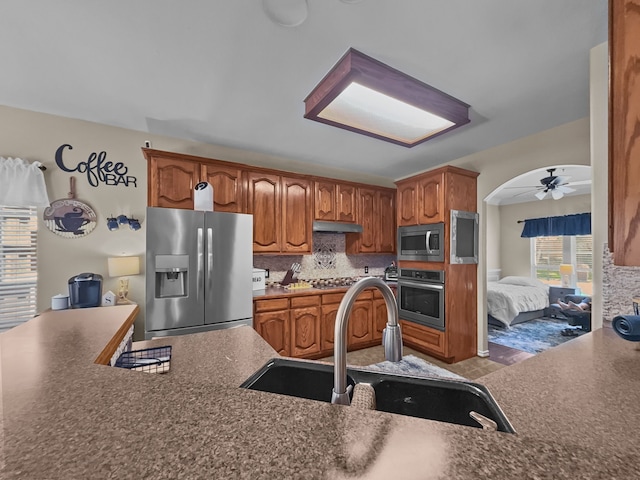 8600 La Quinta Ln, Mckinney, TX 75070 - kitchen with appliances with stainless steel finishes, dark countertops, backsplash, and a ceiling fan
