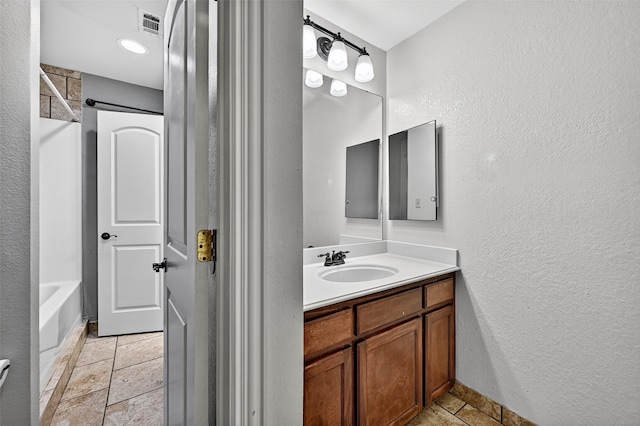 109 Lauren Ln, Pottsboro, TX 75076 - full bath featuring vanity, a textured wall, stone tile floors, and shower / bath combination
