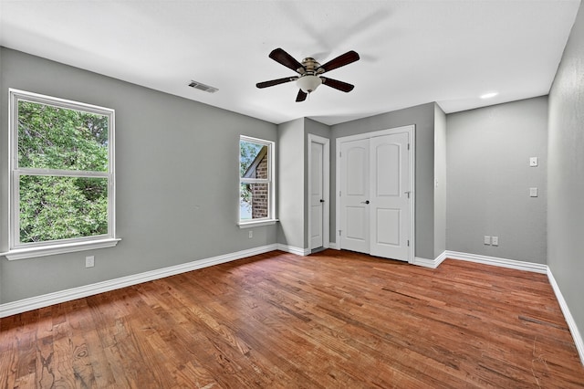 109 Lauren Ln, Pottsboro, TX 75076 - unfurnished bedroom featuring multiple windows, wood finished floors, and two closets