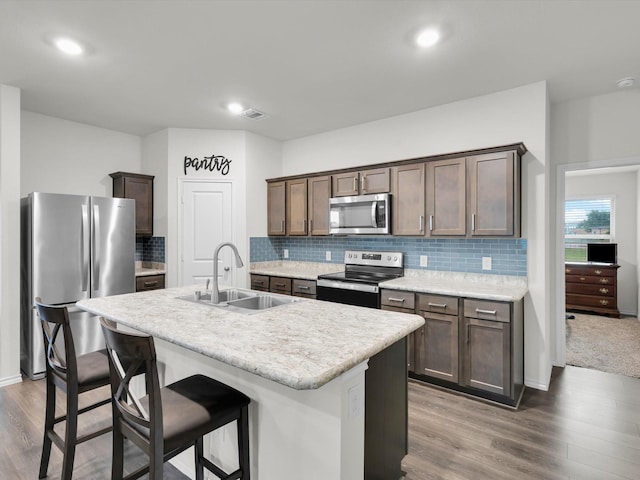 3100 Singleton Rd, Forney, TX 75126 - kitchen featuring stainless steel appliances, light wood-style floors, dark brown cabinetry, tasteful backsplash, and recessed lighting