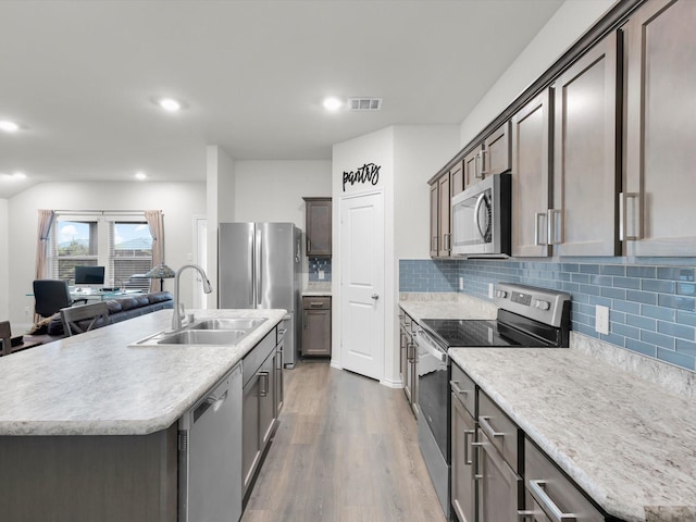 3100 Singleton Rd, Forney, TX 75126 - kitchen with appliances with stainless steel finishes, dark wood-style floors, backsplash, an island with sink, and recessed lighting
