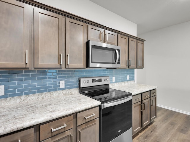 3100 Singleton Rd, Forney, TX 75126 - kitchen featuring appliances with stainless steel finishes, dark wood-style floors, light countertops, and tasteful backsplash