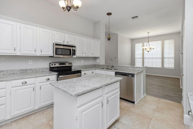 5006 Baton Rouge Blvd, Frisco, TX 75035 - kitchen featuring stainless steel appliances, a chandelier, light tile patterned flooring, a peninsula, and white cabinetry
