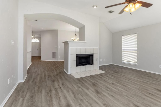 5006 Baton Rouge Blvd, Frisco, TX 75035 - unfurnished living room featuring ceiling fan, wood finished floors, lofted ceiling, a fireplace, and arched walkways