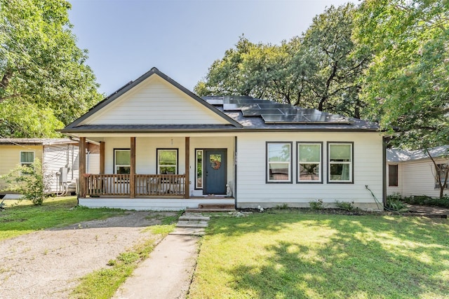 1020 Water St, Waxahachie, TX 75165 - view of front of property with a porch, roof mounted solar panels, a front lawn, and a shingled roof