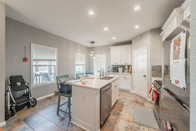 1020 Water St, Waxahachie, TX 75165 - kitchen with appliances with stainless steel finishes, an island with sink, white cabinets, decorative backsplash, and recessed lighting