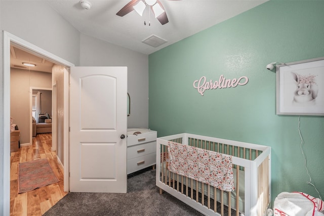 1020 Water St, Waxahachie, TX 75165 - bedroom featuring lofted ceiling, a crib, ceiling fan, and wood finished floors