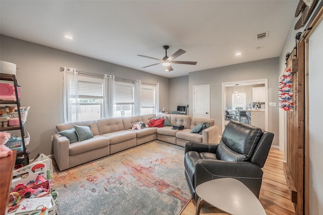 1020 Water St, Waxahachie, TX 75165 - living area featuring light wood-style flooring, a ceiling fan, a barn door, and recessed lighting