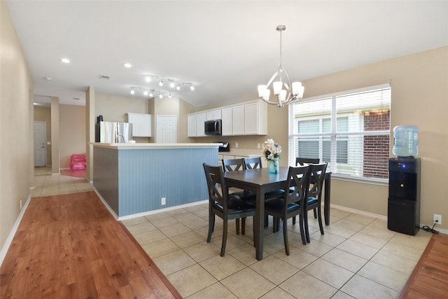 8436 Minturn Dr, Fort Worth, TX 76131 - dining room featuring a chandelier, light wood finished floors, and vaulted ceiling
