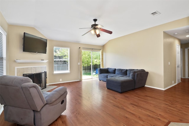 8436 Minturn Dr, Fort Worth, TX 76131 - living room featuring vaulted ceiling, a ceiling fan, wood finished floors, and a tiled fireplace