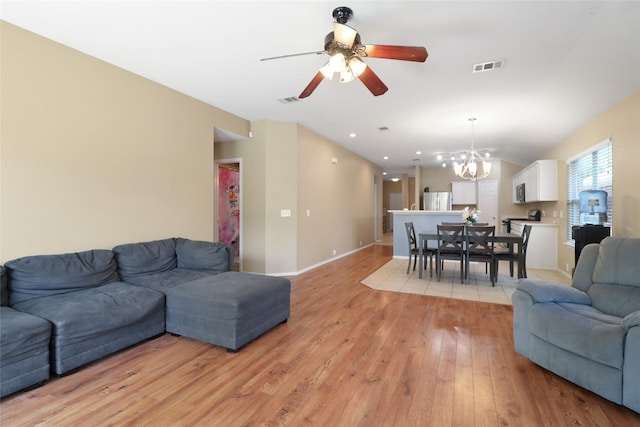 8436 Minturn Dr, Fort Worth, TX 76131 - living area featuring light wood-type flooring, a chandelier, and a ceiling fan