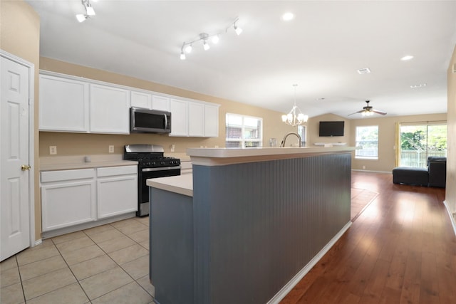 8436 Minturn Dr, Fort Worth, TX 76131 - kitchen with appliances with stainless steel finishes, light countertops, a kitchen island with sink, white cabinets, and open floor plan