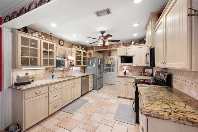 1121 W 3rd Ave, Corsicana, TX 75110 - kitchen featuring appliances with stainless steel finishes, tasteful backsplash, recessed lighting, a ceiling fan, and glass insert cabinets