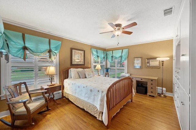 1121 W 3rd Ave, Corsicana, TX 75110 - bedroom featuring light wood finished floors, crown molding, a textured ceiling, baseboard heating, and a ceiling fan
