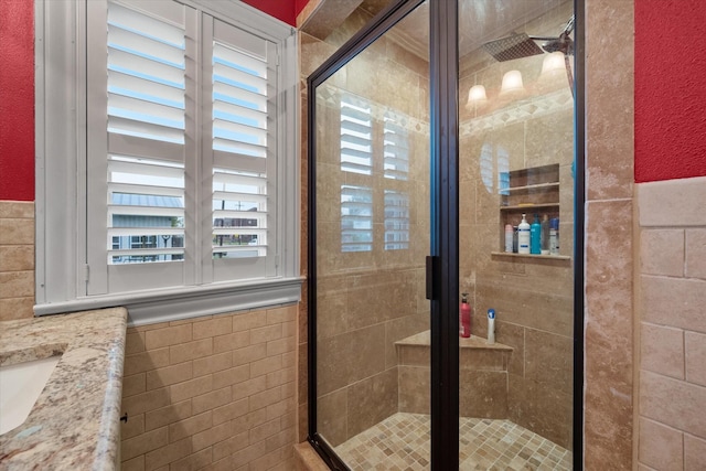 1121 W 3rd Ave, Corsicana, TX 75110 - full bathroom featuring a shower stall, tile walls, and a wainscoted wall