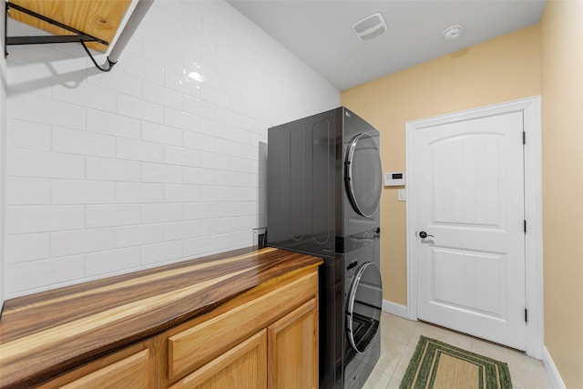 641 Woodridge Dr, Oak Point, TX 75068 - laundry area with stacked washer / drying machine, light tile patterned floors, and cabinet space