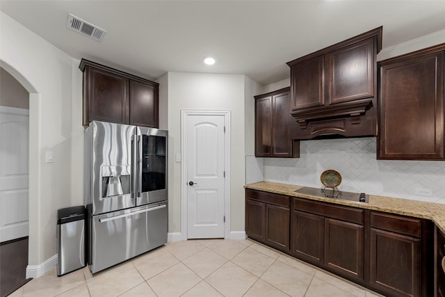 641 Woodridge Dr, Oak Point, TX 75068 - kitchen featuring stainless steel refrigerator with ice dispenser, black electric stovetop, arched walkways, light stone counters, and dark brown cabinets