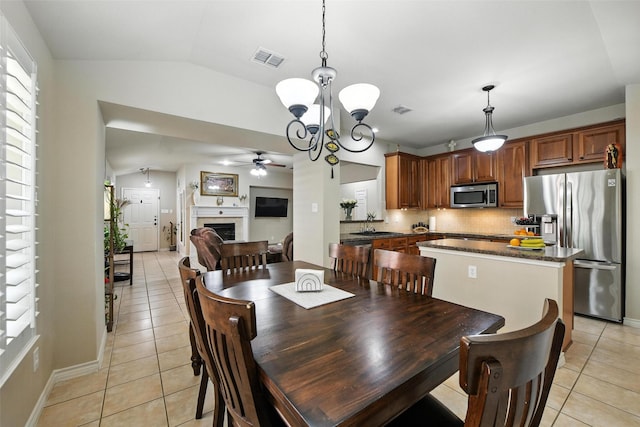 2509 Creek Villas Dr, Bedford, TX 76022 - dining space with light tile patterned floors, a ceiling fan, a fireplace, a chandelier, and lofted ceiling