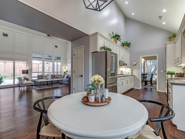 4597 Hallmark Dr, Plano, TX 75024 - dining area with high vaulted ceiling, dark wood-type flooring, and recessed lighting