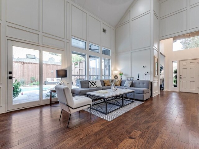 4597 Hallmark Dr, Plano, TX 75024 - living area featuring high vaulted ceiling, a decorative wall, dark wood finished floors, and healthy amount of natural light