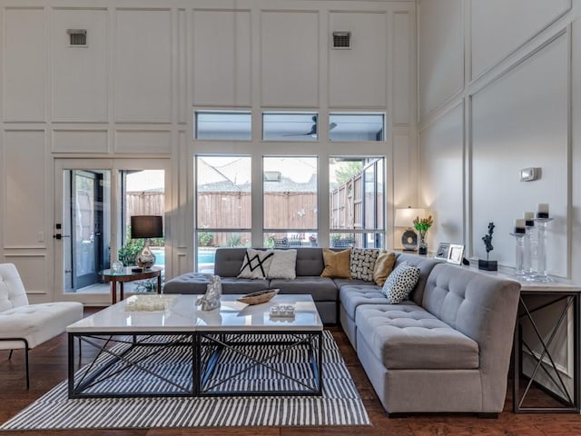 4597 Hallmark Dr, Plano, TX 75024 - living room featuring a decorative wall, a towering ceiling, and dark wood-type flooring
