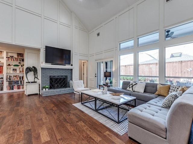 4597 Hallmark Dr, Plano, TX 75024 - living area featuring a decorative wall, high vaulted ceiling, a fireplace, and dark wood finished floors