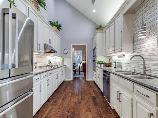 4597 Hallmark Dr, Plano, TX 75024 - kitchen featuring appliances with stainless steel finishes, decorative backsplash, white cabinets, under cabinet range hood, and stone counters