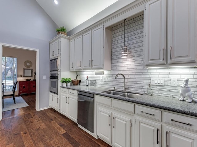 4597 Hallmark Dr, Plano, TX 75024 - kitchen with appliances with stainless steel finishes, tasteful backsplash, dark wood-type flooring, high vaulted ceiling, and dark stone counters