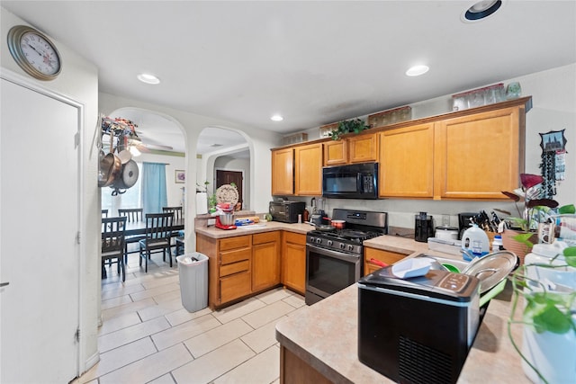 3440 Baby Doe Ct, Fort Worth, TX 76137 - kitchen with gas stove, black microwave, light countertops, arched walkways, and light tile patterned floors