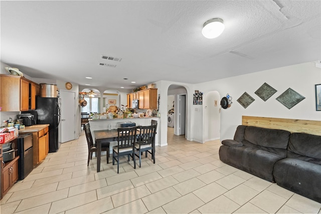 3440 Baby Doe Ct, Fort Worth, TX 76137 - dining area with arched walkways, washer / clothes dryer, a textured ceiling, a ceiling fan, and light tile patterned floors