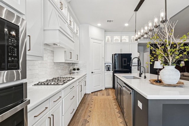 7709 Waterside, The Colony, TX 75056 - kitchen with appliances with stainless steel finishes, light wood finished floors, light countertops, white cabinets, and recessed lighting