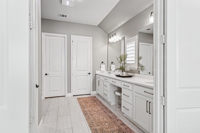 7709 Waterside, The Colony, TX 75056 - bathroom featuring double vanity, vaulted ceiling, and tile patterned flooring