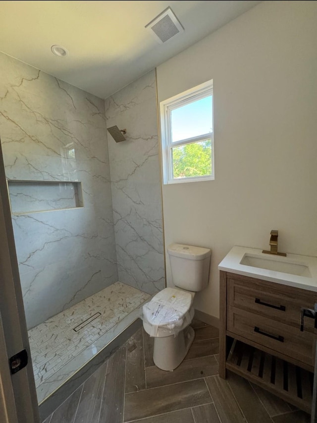 908 S Ewing Ave, Dallas, TX 75203 - bathroom with vanity, a marble finish shower, and wood finished floors
